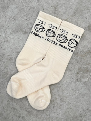 White socks with black text on a gray concrete surface